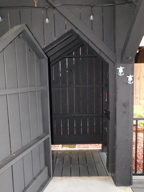 Une porte en bois, dotée d’une poignée en métal et d’un trou de serrure, qui donne sur une entrée abritée.