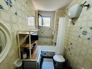 Un bagno piccolo con il water, un lavandino e una doccia.