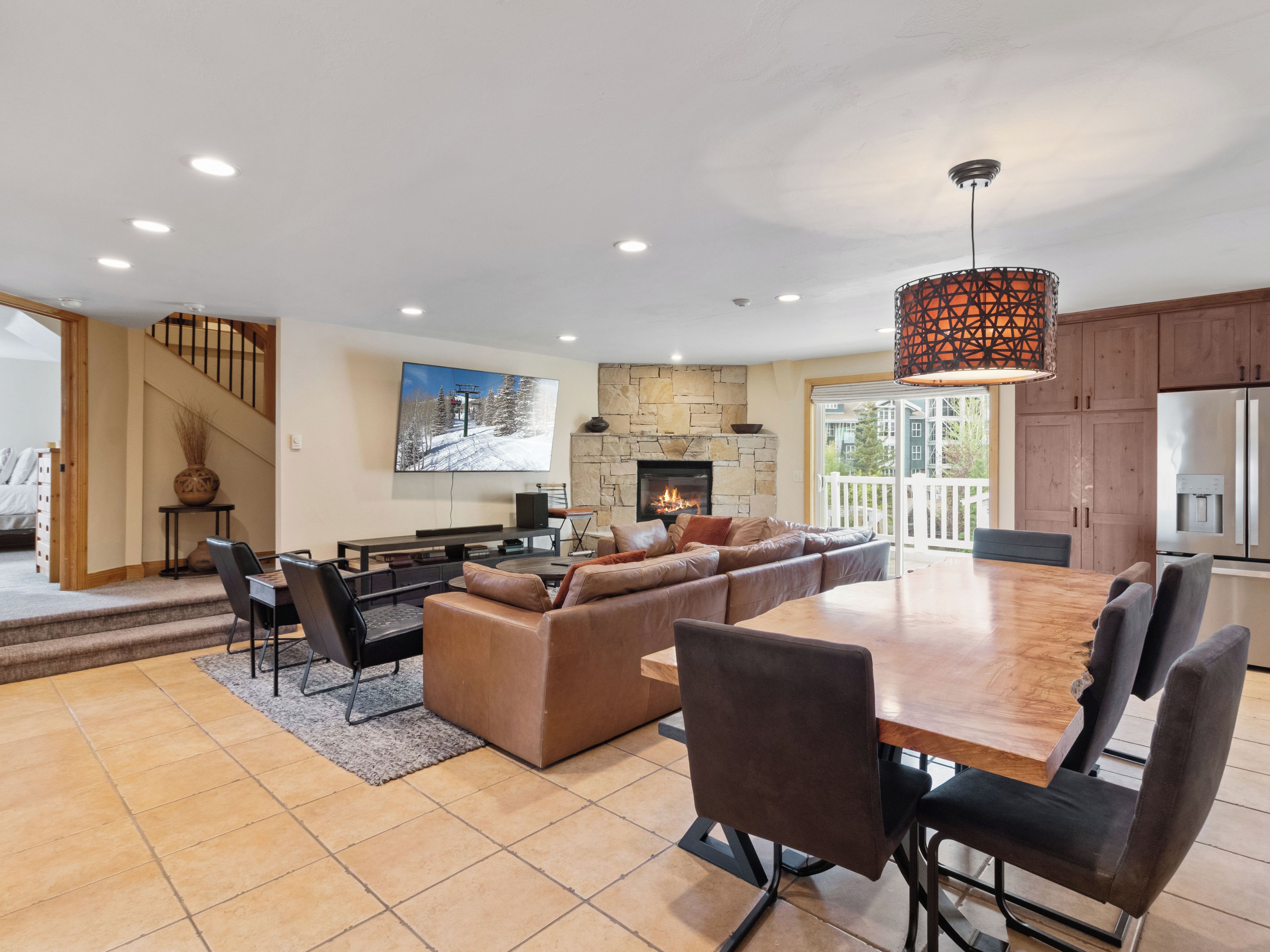 A spacious living area with a fireplace, a large dining table, and a cozy seating arrangement.