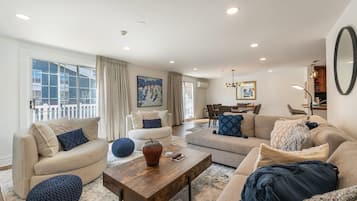 A spacious living room with a large window, a fireplace, and a dining area.