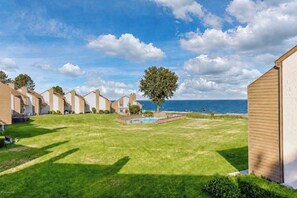 A row of beachside cottages with a swimming pool and a view of the ocean. - North Shore Retreat | Beachfront • Pool • Walkable (South Haven)