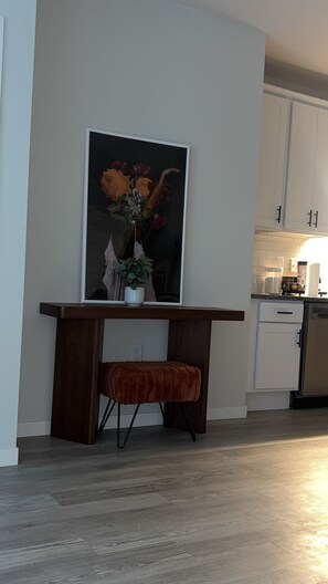 Een moderne keuken met witte kasten, een houten aanrechtblad en een eethoek met een bank.