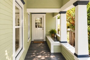 A covered porch with a white door, a bench, and a potted plant. - The Moody Modern*2KING beds*2bath*Walkable* (Albany)