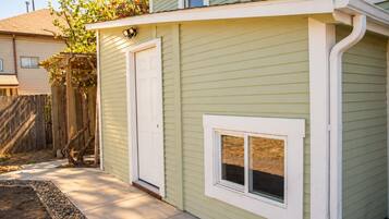Un immeuble résidentiel avec une porte d’entrée, une petite fenêtre et une clôture en bois.