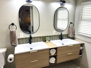 A bathroom with two sinks, a mirror, towel rings, and a toilet. - The Moody Modern*2KING beds*2bath*Walkable* (Albany)