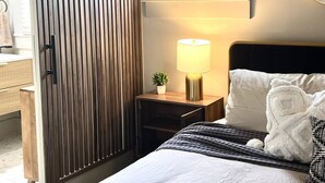 Ein Hotelzimmer mit Bett, Nachttischlampe und Fenster.