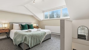 A bedroom with a bed, a nightstand, a window, and a radiator. - Stunning 3B Home, ideal for leisure & contractors (Clitheroe)