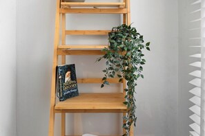 A wooden bookshelf with a book titled 'Philippa Gregory' and a green plant.