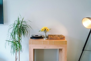 A wooden console table with a vase of yellow flowers, a bowl, and a woven basket. - Spacious 6 bedroom house, with private parking (Manchester, London)