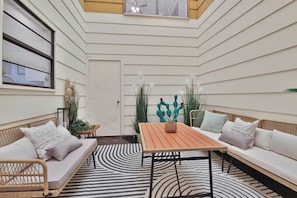 A sunlit room with a sofa, a table, and a patterned rug. - Peaceful Lubbock Retreat with Private Indoor Atrium (Lubbock)