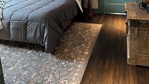 A bedroom with a bed, a bicycle wall decoration, a door, and a nightstand with a lamp. - The Fox Den in delightful Columbia (Columbia)