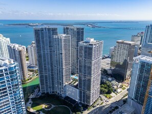 A high-rise building complex with multiple skyscrapers, a marina, and a bridge in the background. - High-Floor 1BR | Bay & City Views | Brickell (Miami)
