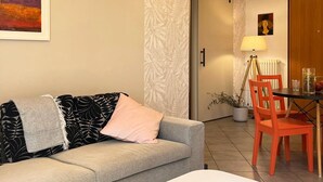 Una sala de estar moderna con un sofá, una mesa de centro y un comedor con sillas.