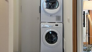 Una sala de lavandería con lavadoras apiladas y una secadora.