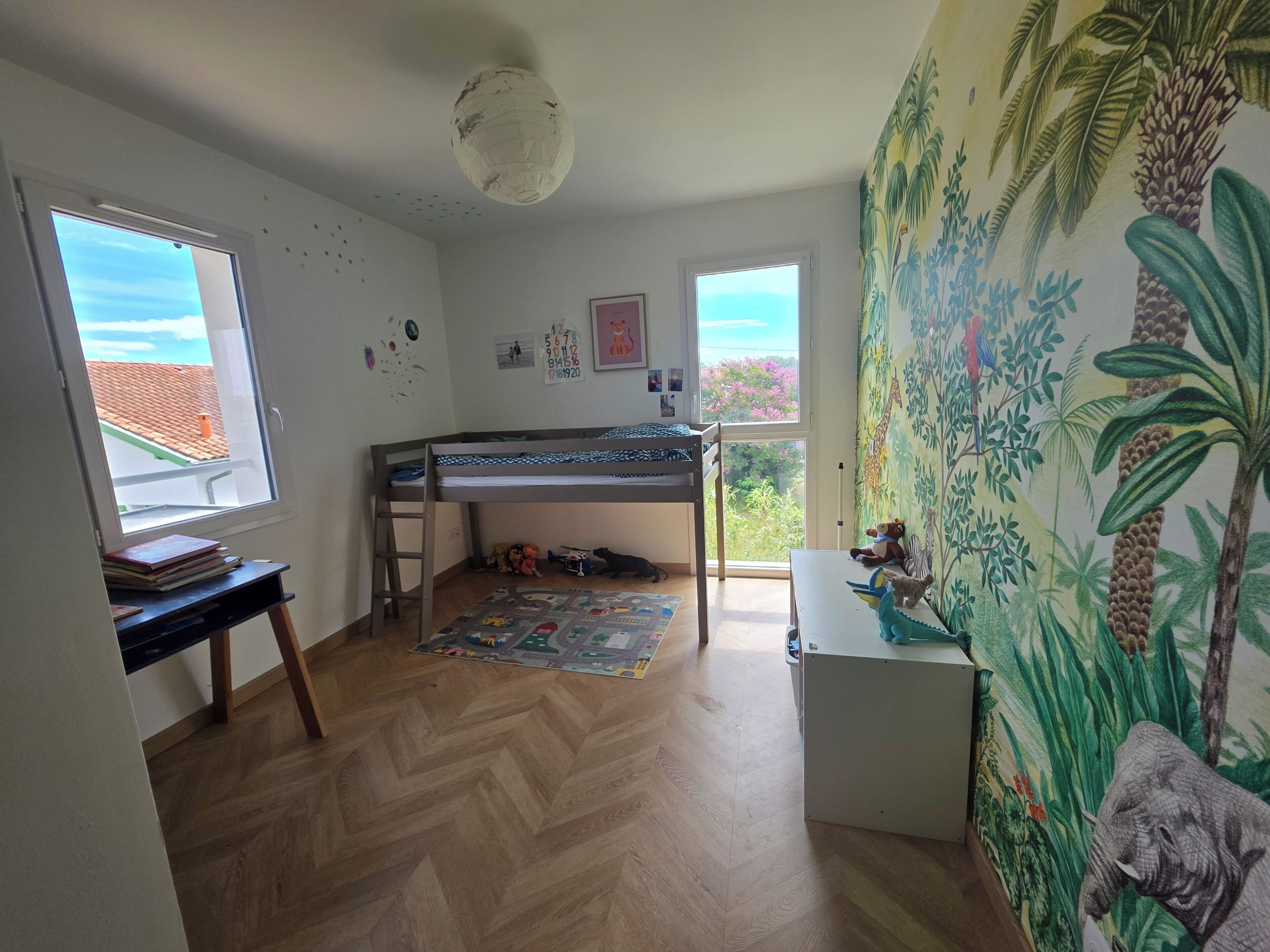 Habitación infantil con literas, un escritorio y una ventana con vistas.