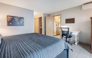 A hotel room with a bed, a desk, and a kitchenette. - Top Floor Downtown Condo With Balcony & Grill! (Bend)