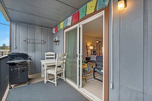 Ein überdachter Außenbereich mit Grill, Tisch und Stühlen.