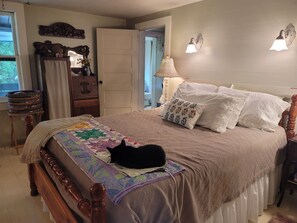 A bedroom with a bed, a quilt, a lamp, a dresser, and a mirror. - Peaceful and cozy 1-bedroom historic creek-side cabin in Glenville with AC (Glenville)