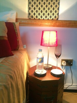 A bedside table with a water bottle, a wine glass, and a lamp. - A/C True Blue Apt base -perfect for SGU Airport - Yacht life, Beach, Fast WiFi (Saint George's)