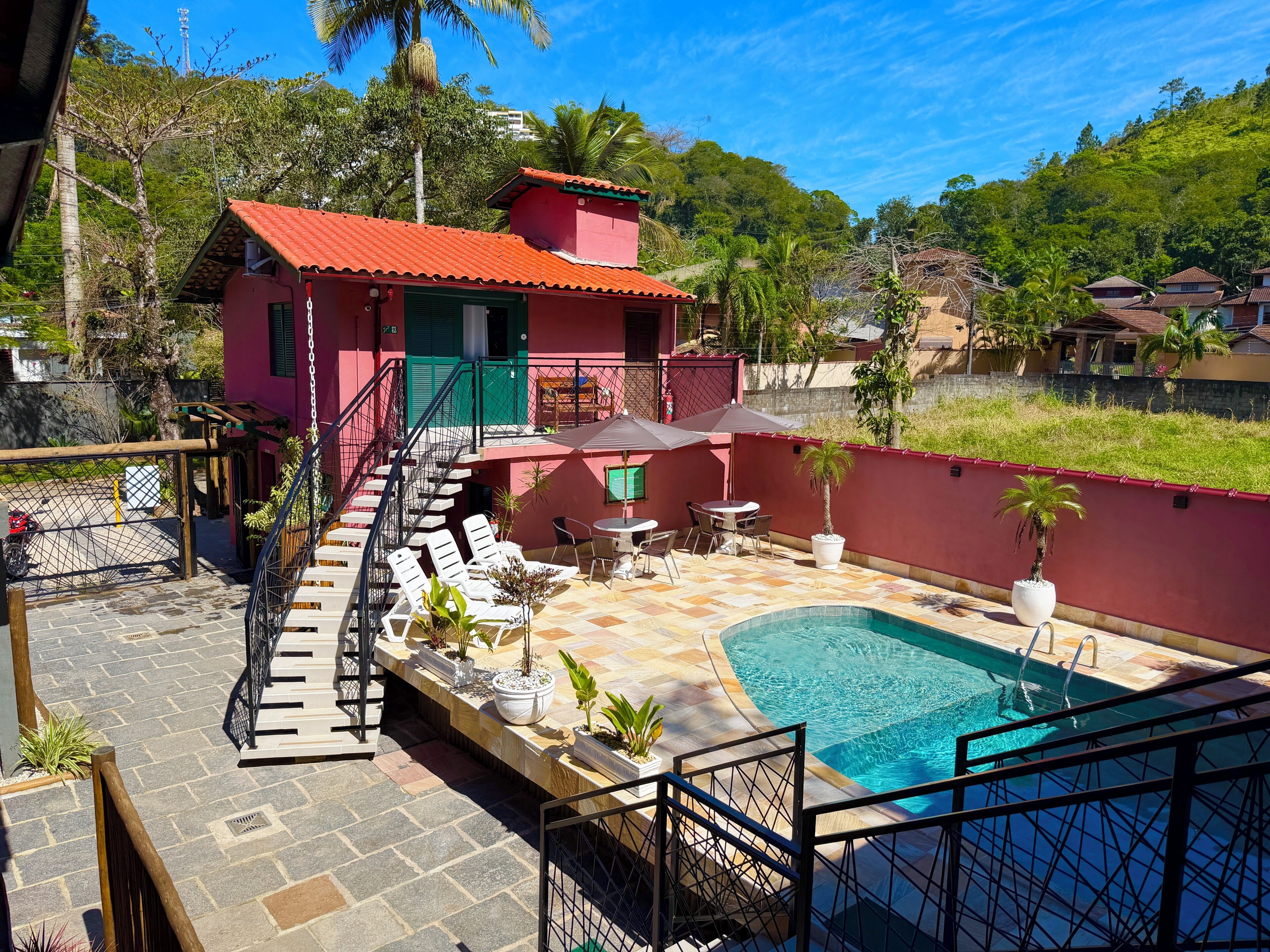 Un bâtiment à deux étages, doté d’un toit rouge et d’une piscine.