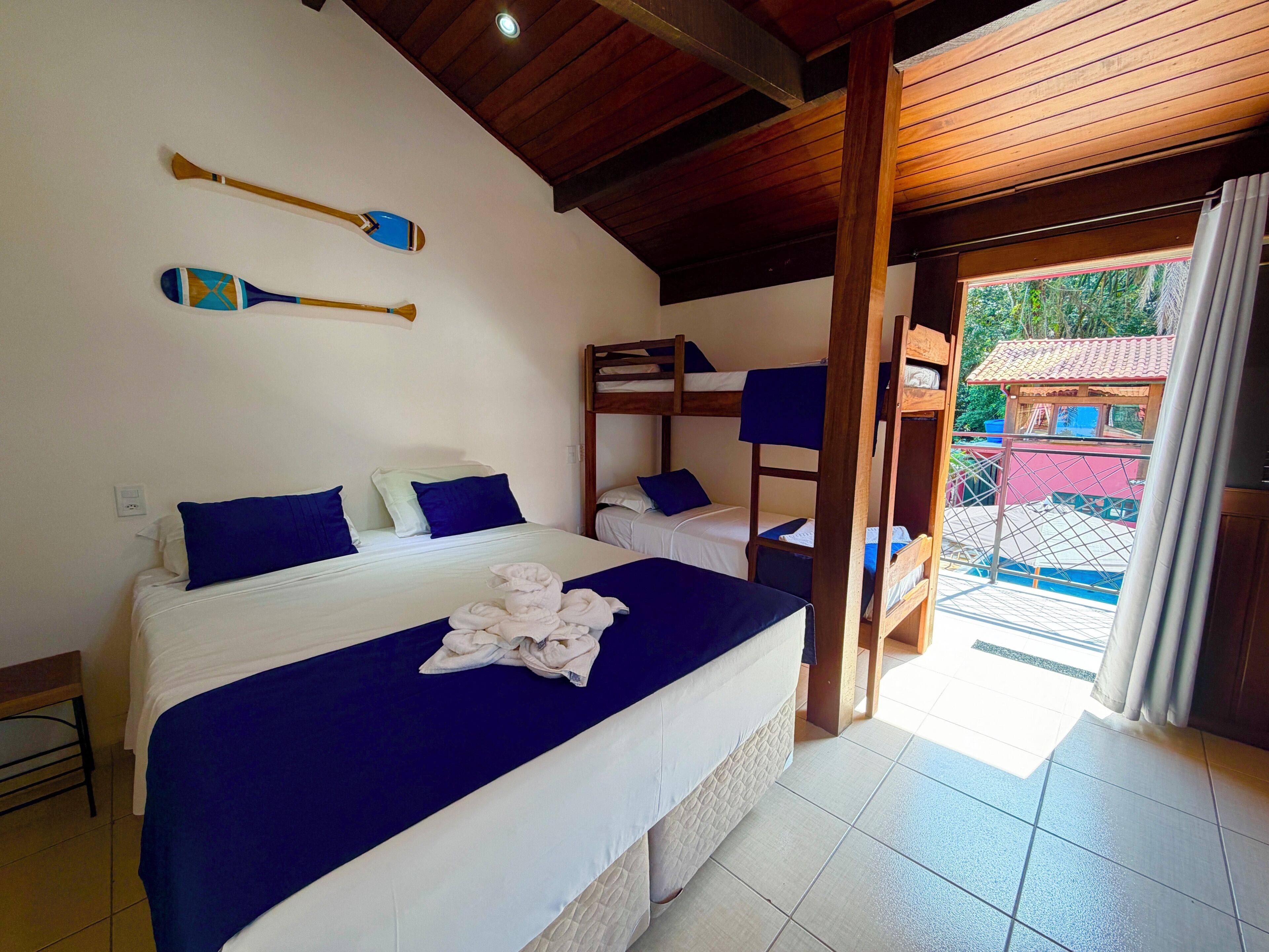 Una habitación con cama, literas y vista al exterior.