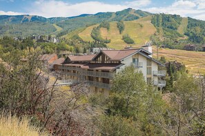 A hotel with a balcony overlooking a valley, surrounded by trees and hills. - ST406 | Newly Modern| Close access + Across Street from Slopes (Steamboat Springs)
