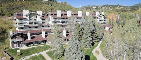 A multi-story hotel with balconies and a pathway leading to the entrance.