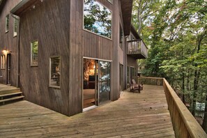 A modern wooden cabin with a deck, large windows, and a stone fireplace. - Briar Hill North Lakefront Contemporary with Private Dock (Lakeville)