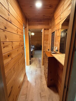 Un interior de fusta amb un passadís que condueix a una habitació.