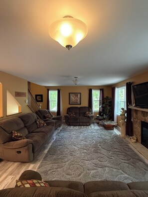 A living room with a sofa set, a fireplace, and a television. - Rocky Road Chalet - Masthope (Lackawaxen)