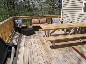 A wooden deck with outdoor furniture including a sofa, chairs, and a table. - Rocky Road Chalet - Masthope (Lackawaxen)