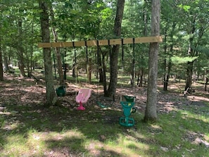 A swing set in a wooded area.