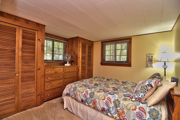 A bedroom with a bed, wooden wardrobe, and a window with blinds. - Sunny Point Lake Wallenpaupack Lakefront with private dock - 4 bedroom sleeps 9 (Lakeville)
