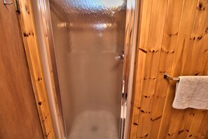 Interior em madeira com porta de vidro que dá para a área do chuveiro.