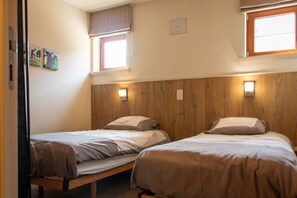 A room with two single beds, a window with blinds, a wall-mounted light, and a small picture. - Accessible Stay at the Alfonsinehoeve (Heers)