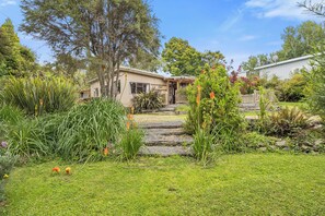 Uma casa com jardim, um caminho de pedra e uma antena parabólica.