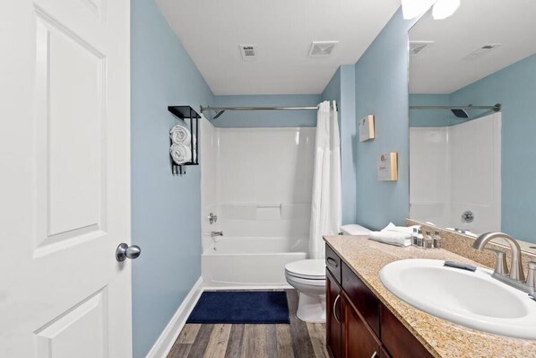 A bathroom with a bathtub, toilet, and sink. - Laketown Wharf 316 (Panama City Beach)