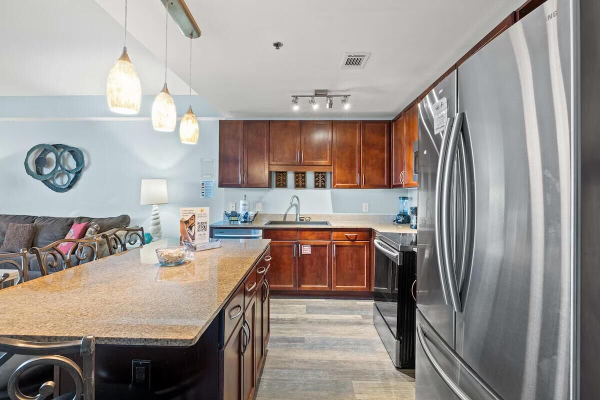 Una cocina moderna con una isla central, electrodomésticos de acero inoxidable y armarios de madera.