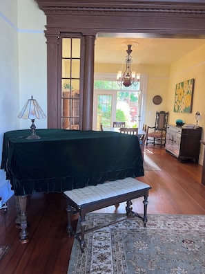 A room with a bed, a bench, a lamp, a chandelier, and a view of the outdoors. - Charming 4-Bed Sausalito Home with Bay Views & Garden Patio near San Francisco (Sausalito)