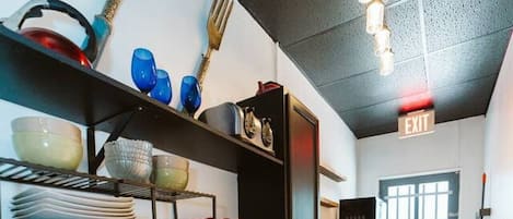 A kitchen with a red sink, wooden cabinets, and a built-in stove.
