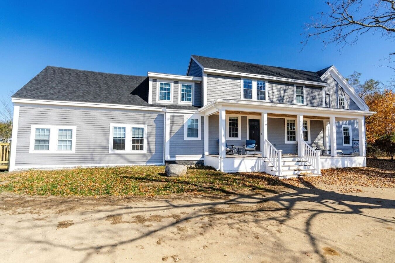 A two-story house with a front porch, a garage, and a driveway.