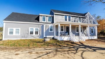 A two-story house with a front porch, a garage, and a driveway.