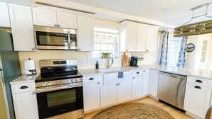 A kitchen with white cabinets, a stainless steel oven, a microwave, and a dishwasher.