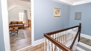 A room with a wooden staircase, a blue wall, and a framed picture.