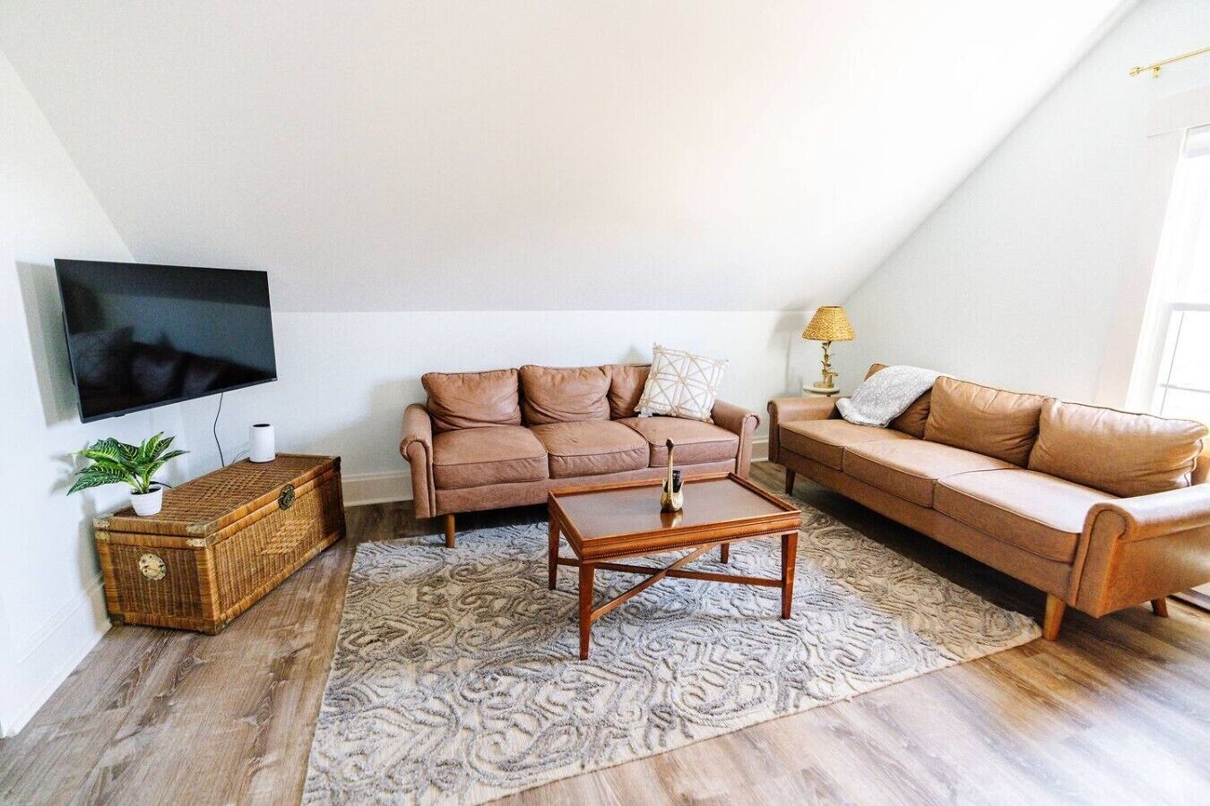 A living room with a sofa set, a coffee table, a TV, and a lamp.
