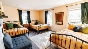Une chambre avec deux lits simples, un canapé et un grand miroir.