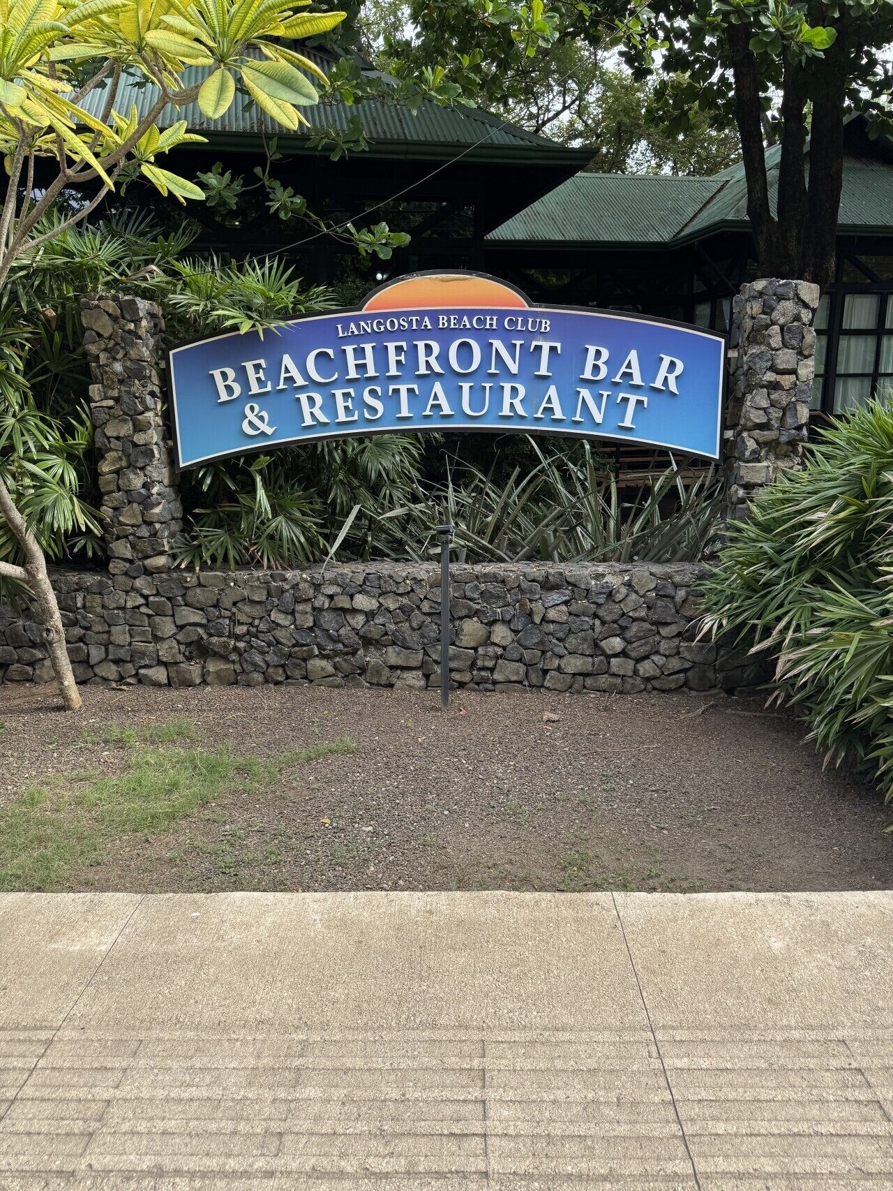 A sign for Beachfront Bar & Restaurant at Langosta Beach Club.