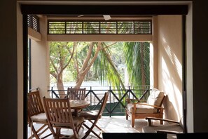 A balcony with a view of trees and a railing. - Beach Club 2 BD Condo|Pool & Ocean|Playa Langosta (Tamarindo)