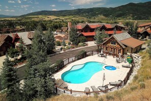 A resort with a swimming pool, outdoor seating, and a view of the surrounding hills. - AC1465 | Perfect Mtn Getaway | Beautiful Valley Views | Close to slopes (Steamboat Springs)