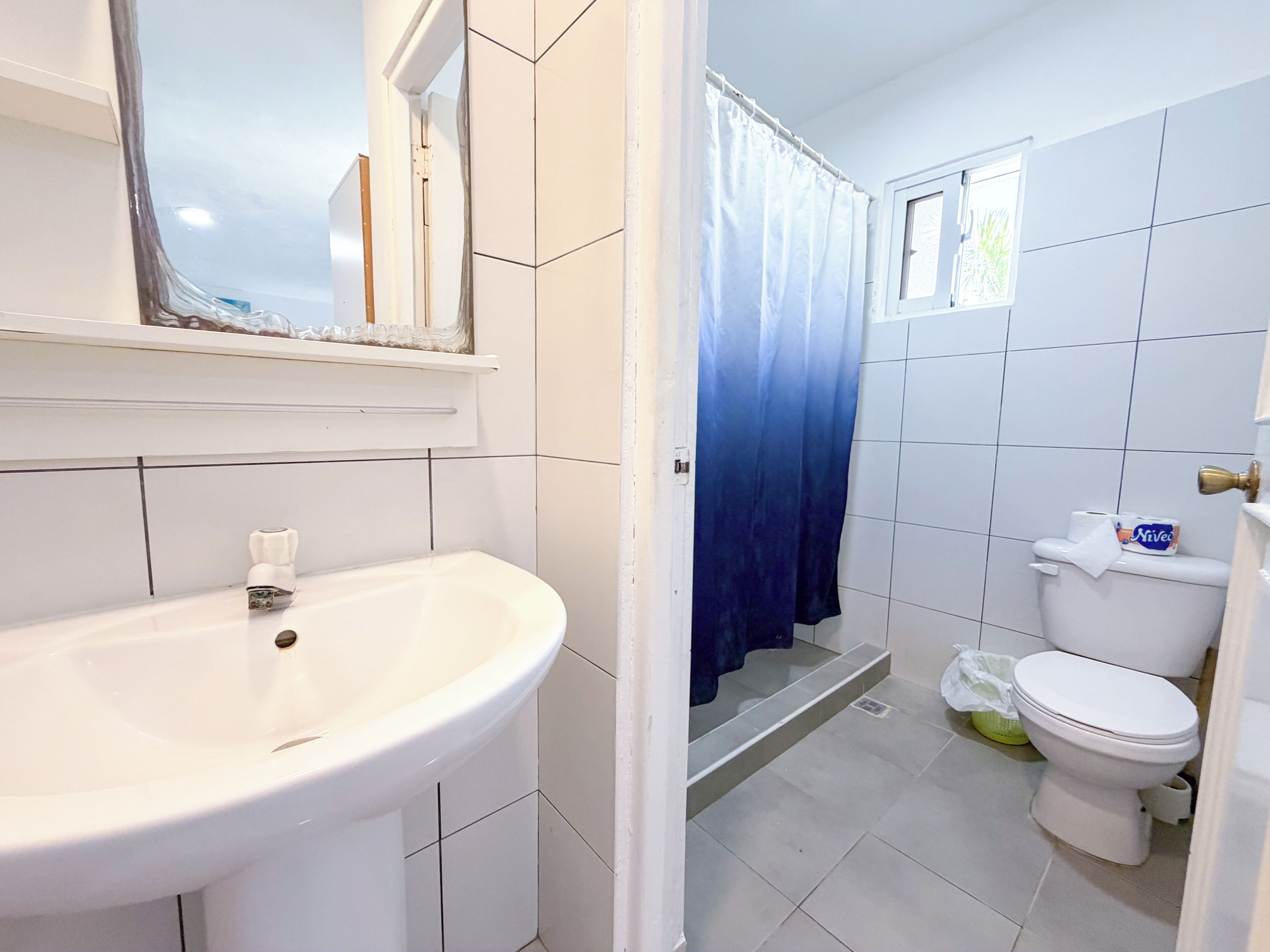 Ein Badezimmer mit einem weißen Waschbecken, einer Toilette und einer Duschvorhang.